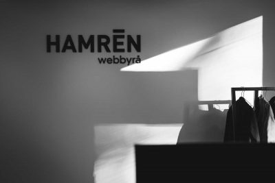 Foto Hamrén kontor. Svartvitt bild av vit vägg där "Hamren Webbyrå" står på väggen